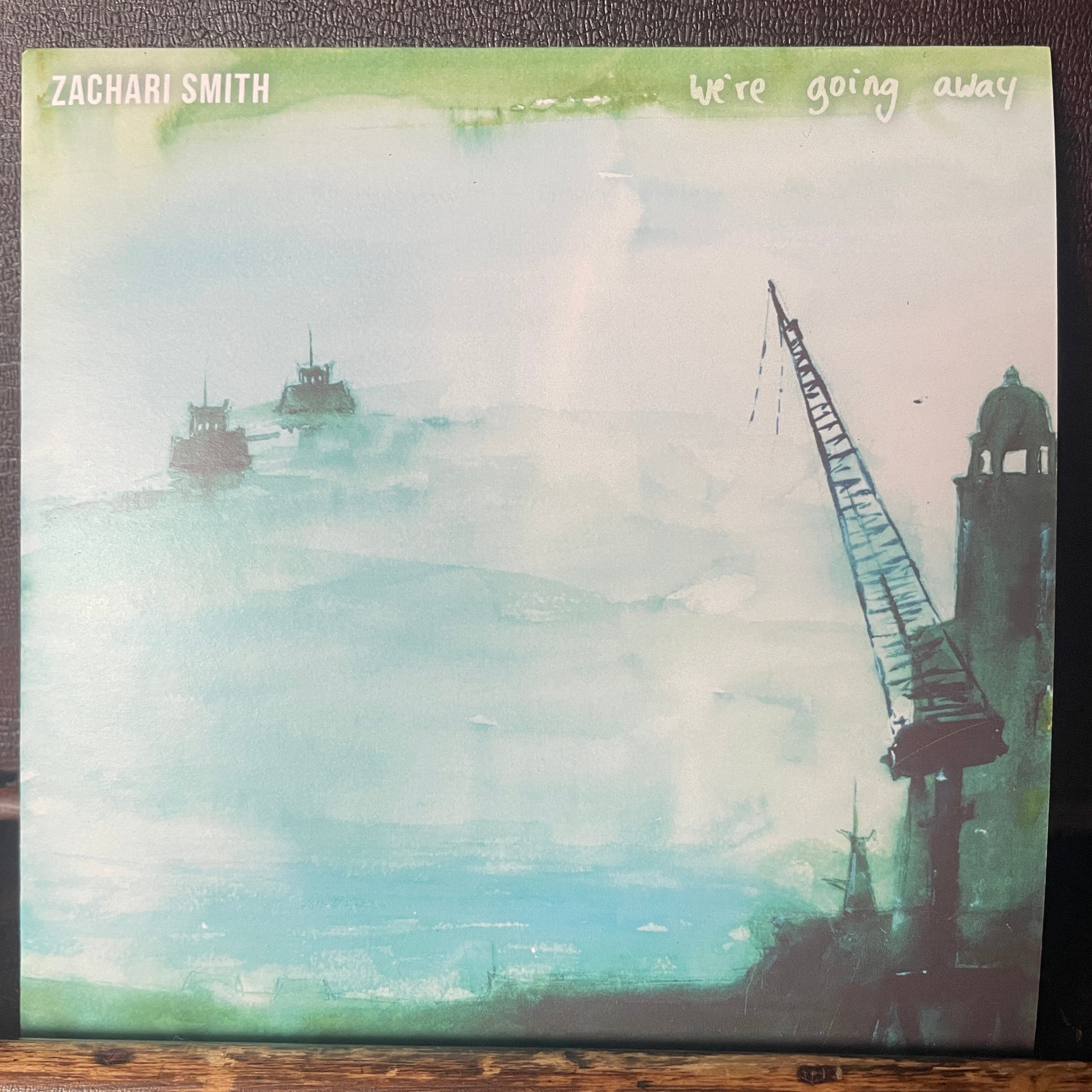 Album cover with a ship illustration and text on a textured surface
